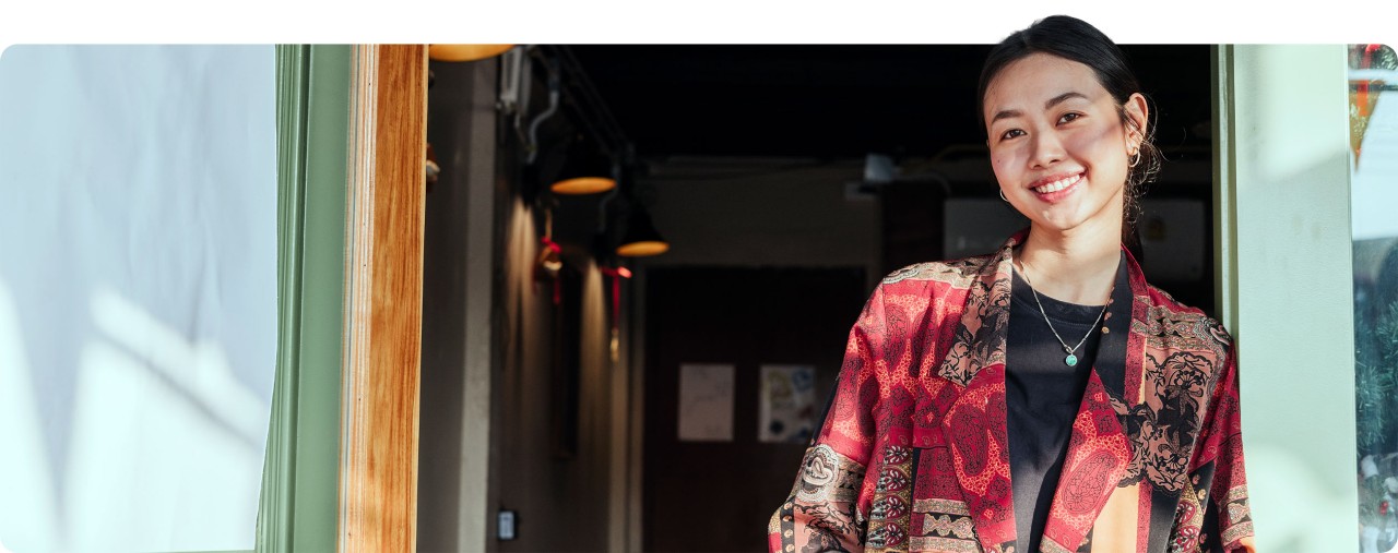 Young female business owner standing in front of her shop
