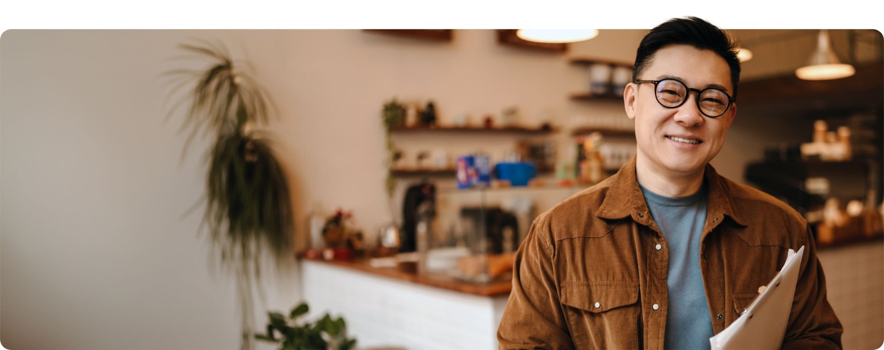 Smiling Asian-American business owner standing in a shop