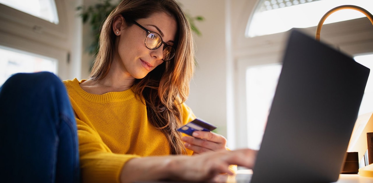 Woman using laptop to make a debit card purchase