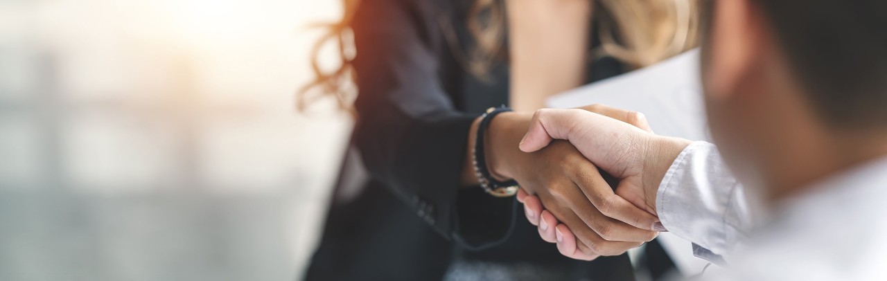 A woman and man shake hands