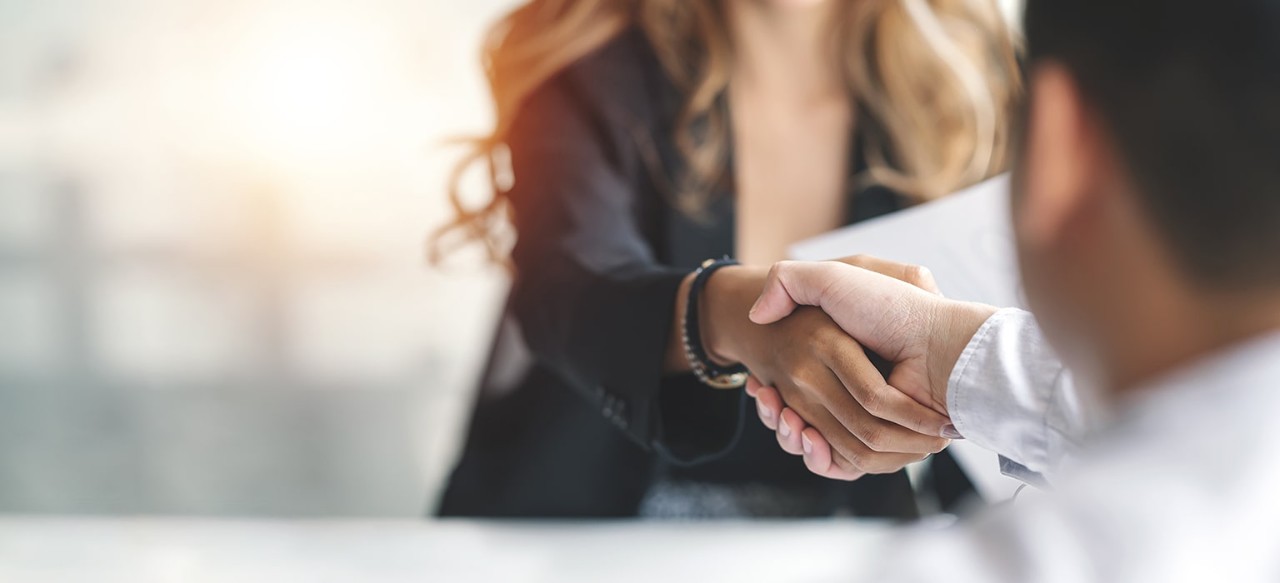 A woman and man shake hands