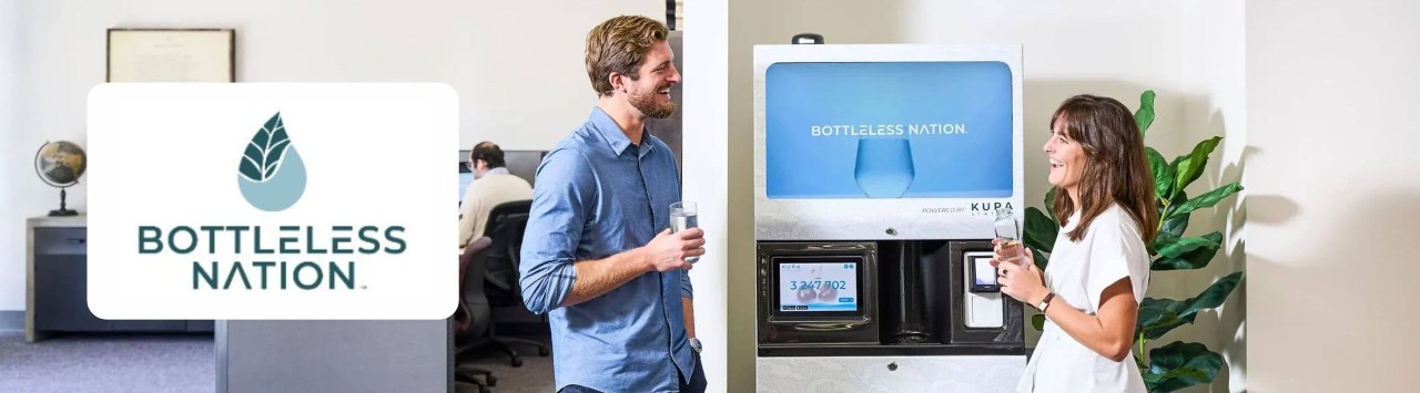 Two young workers in an office talking and smiling around a modern water dispenser, adjacent to superimposed Bottleless Nation logo