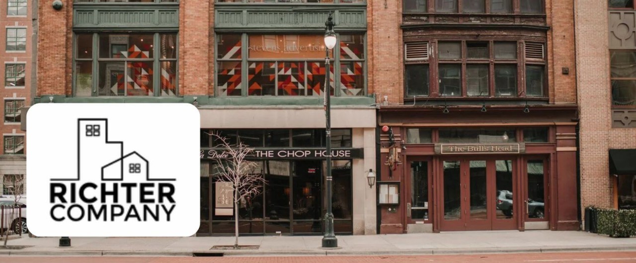Richter Company logo overlaid on a downtown building with two storefronts