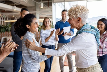 Employees clapping and being recognized by manager