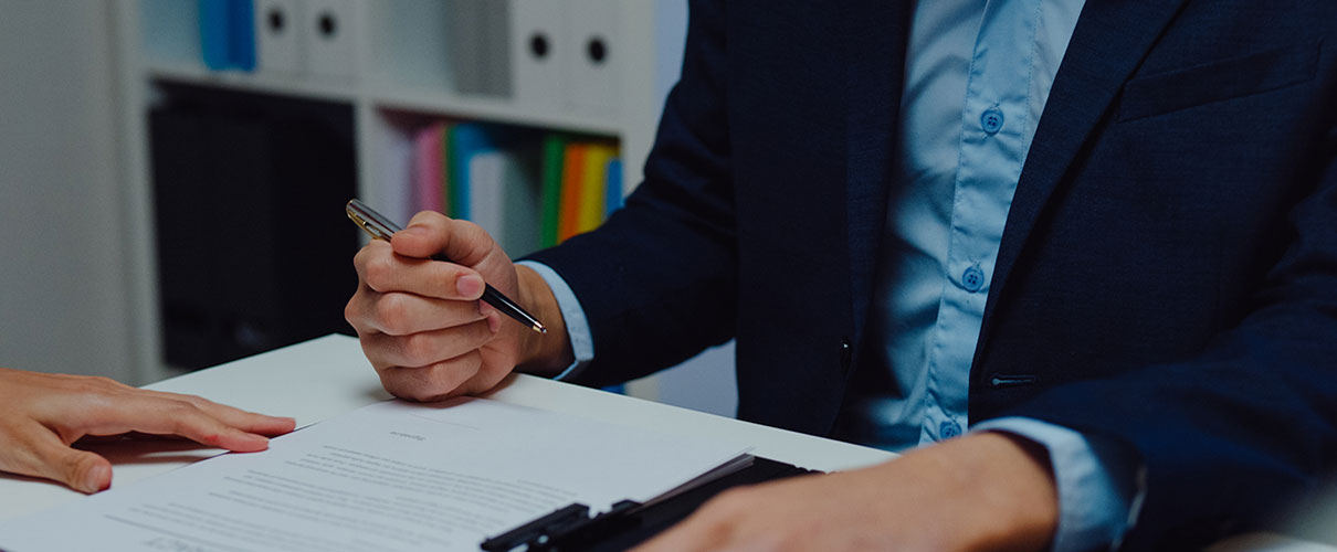 Two people reviewing and signing financial paperwork