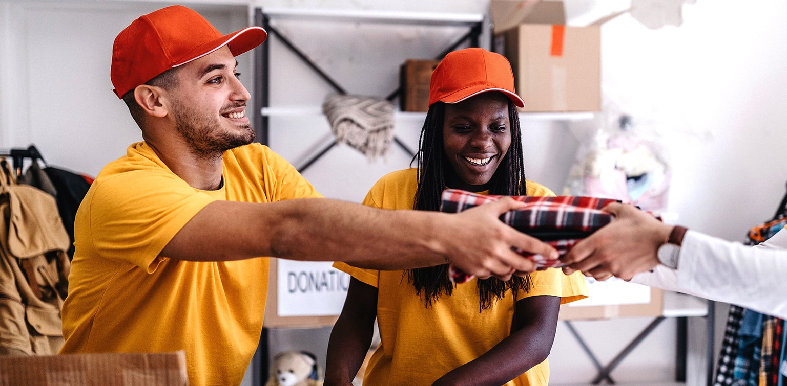 Multiethnic volunteers handing supplies to recipient