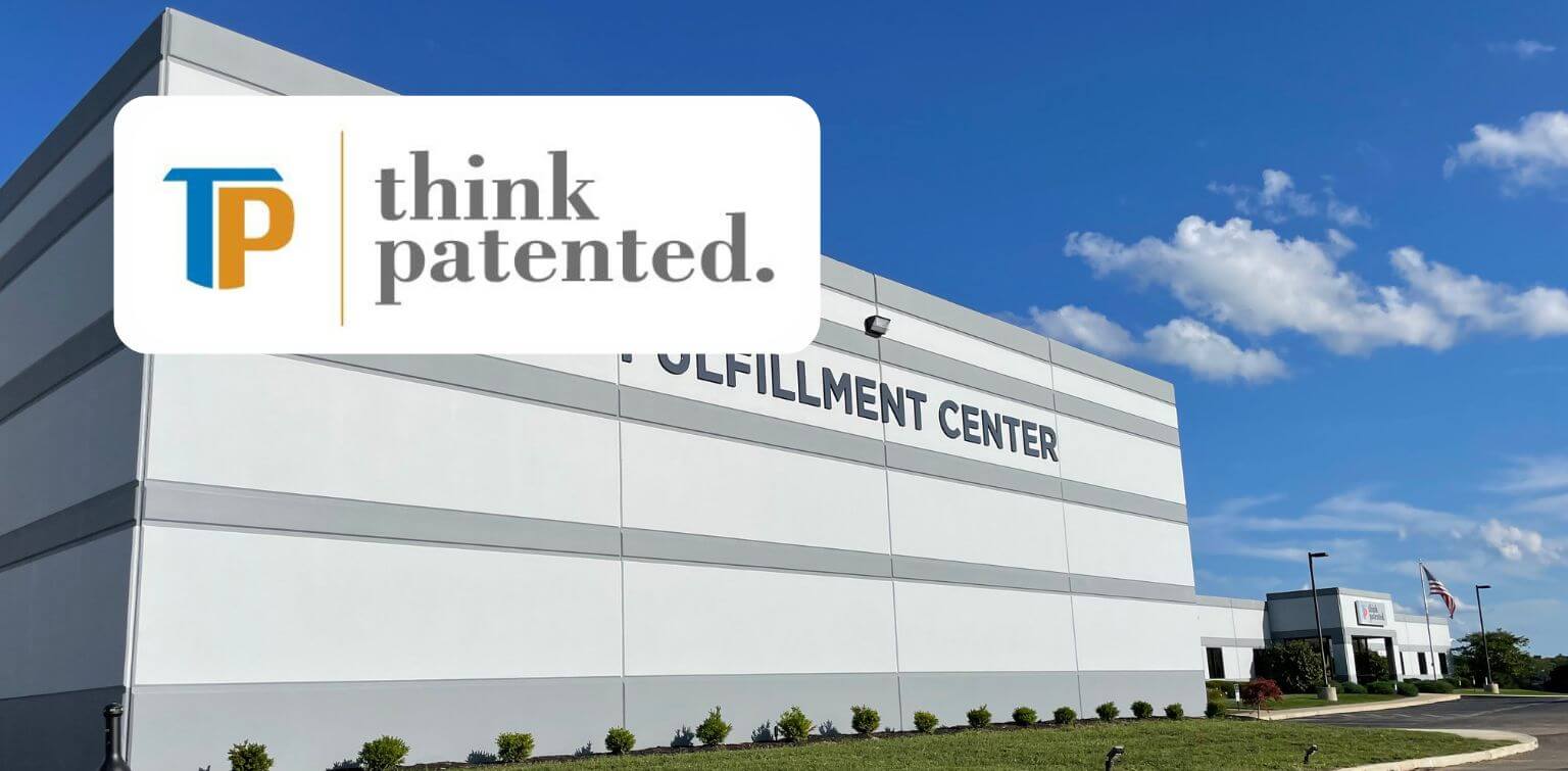 Exterior of an industrial fulfillment center with a blue sky sprinkled with clouds. Logo overlay reads, “Think Patented.”