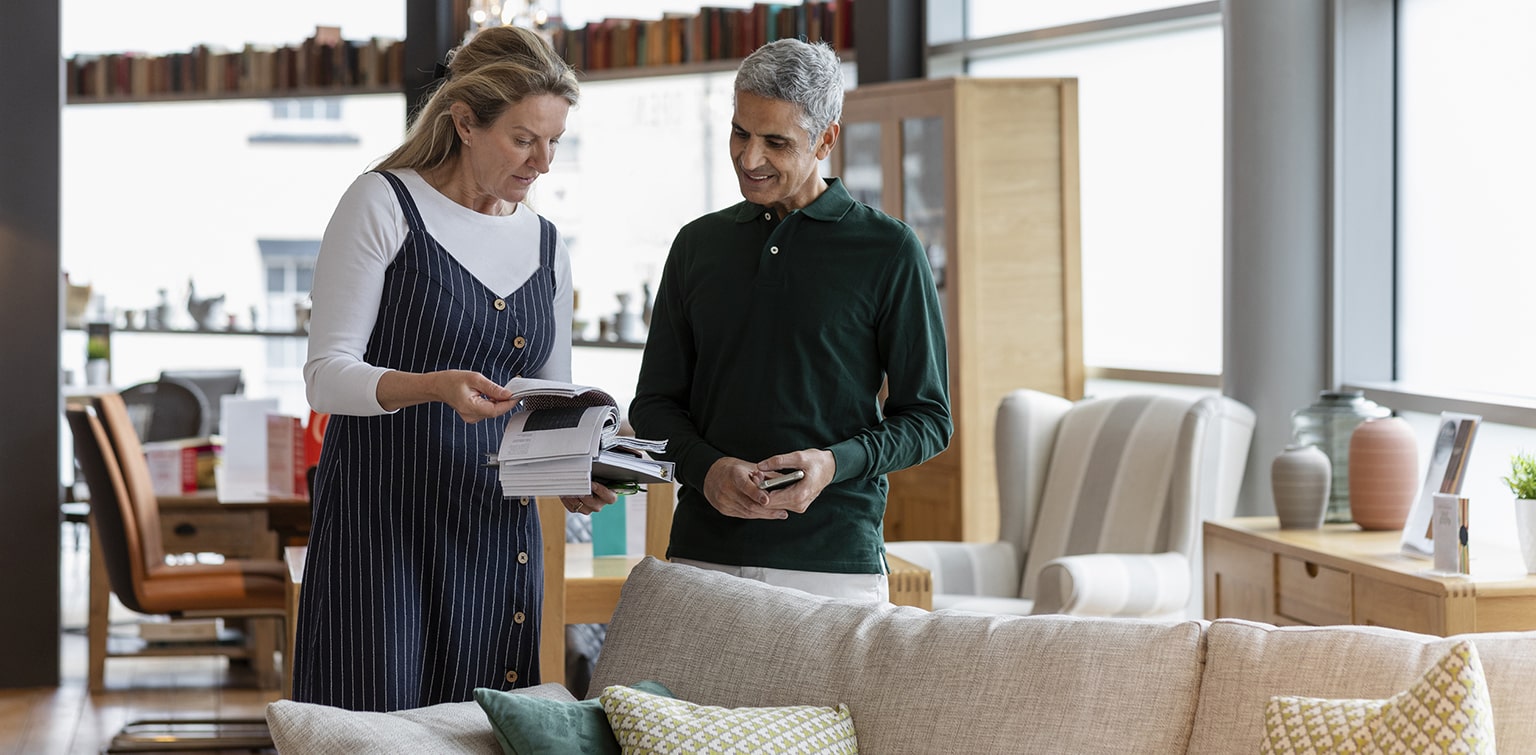 Store employee assisting customer in furniture store