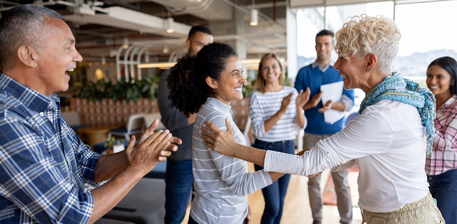 Employees clapping and being recognized by manager