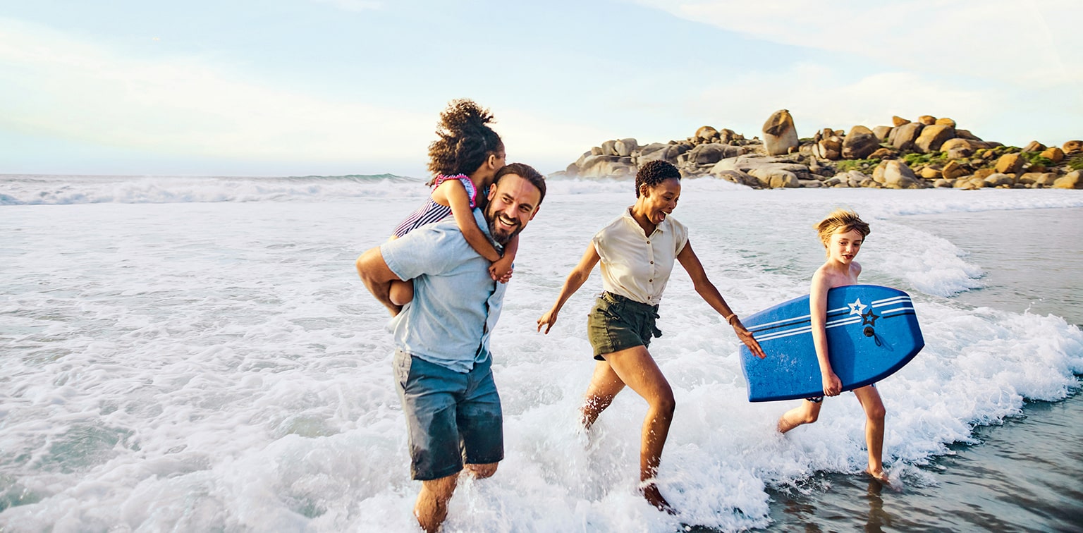 Happy family playing in the surf at the beach