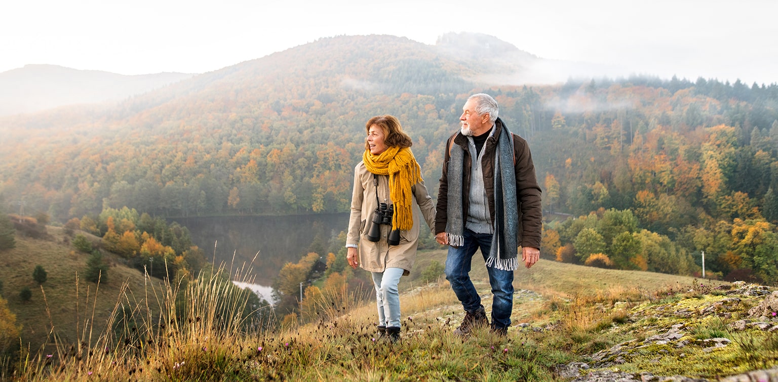 Senior couple hiking in hills overlooking river