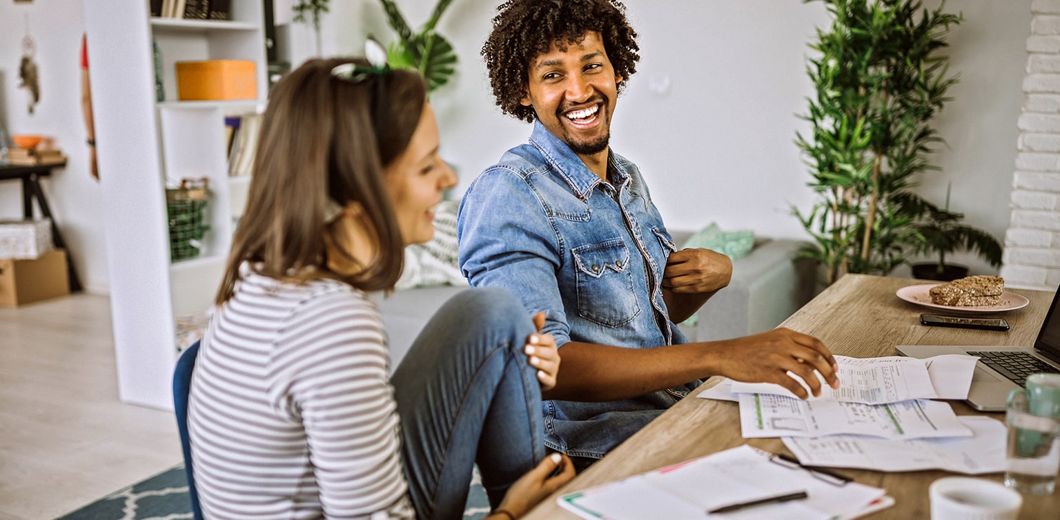 Couple sitting at table reviewing financial documents