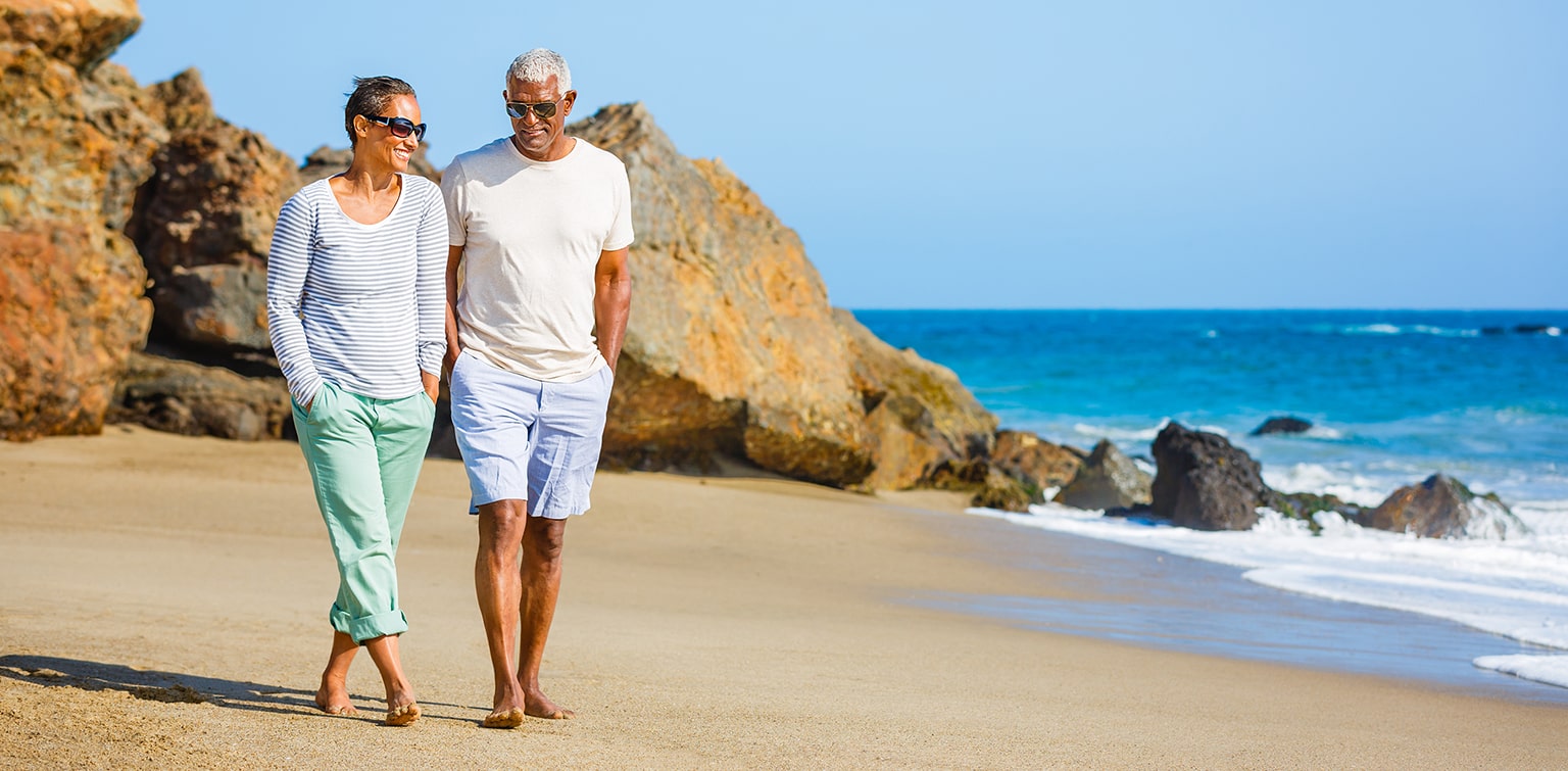 Mature couple walking along beach