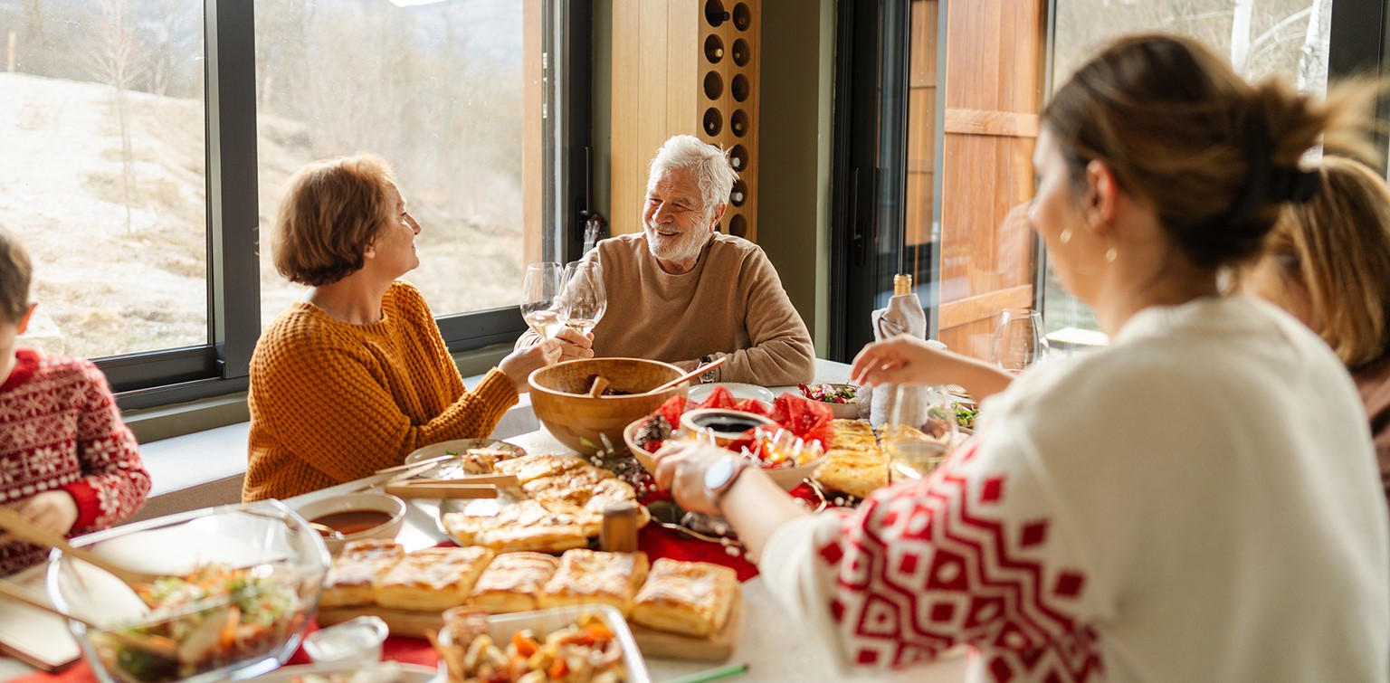 Senior couple and family members gathered around dinner table