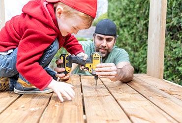 Man and child using power tools