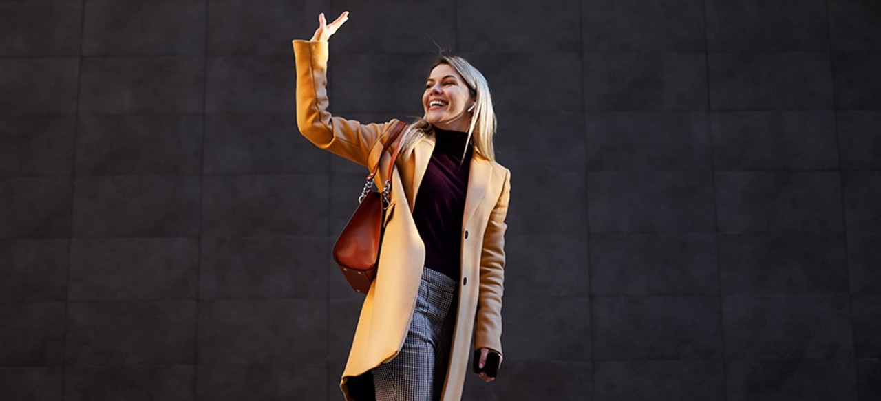 Woman walking away waving goodbye