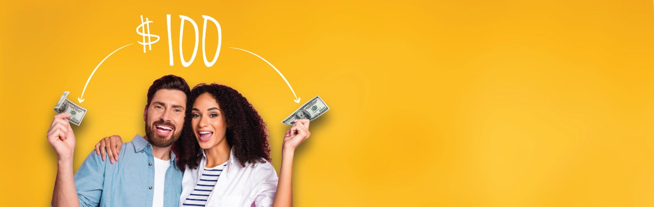Smiling young couple each holding $100 bills