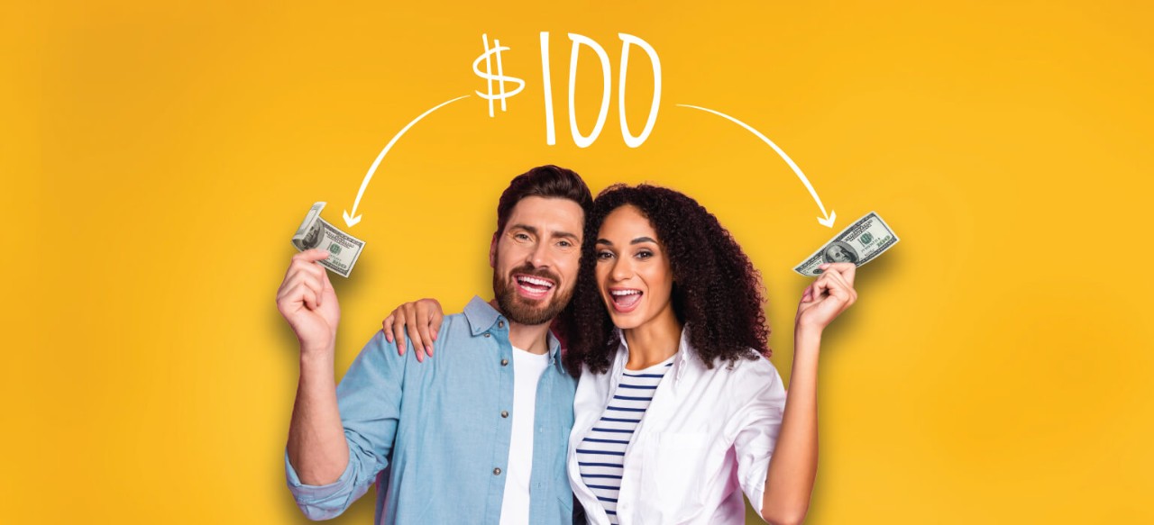 Smiling young couple each holding $100 bills
