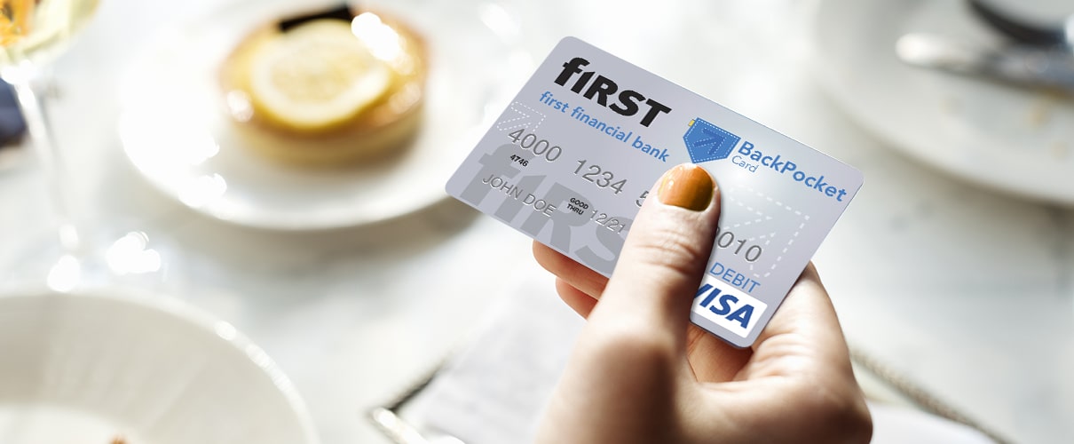 Woman's hand holding BackPocket card at restaurant