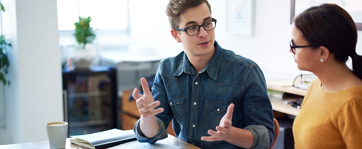 Two people sitting at a table discussing finances.