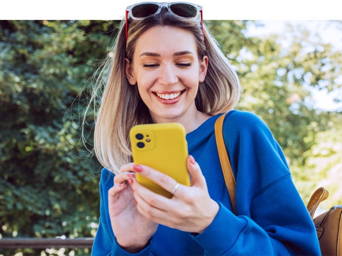 Smiling young woman using smartphone