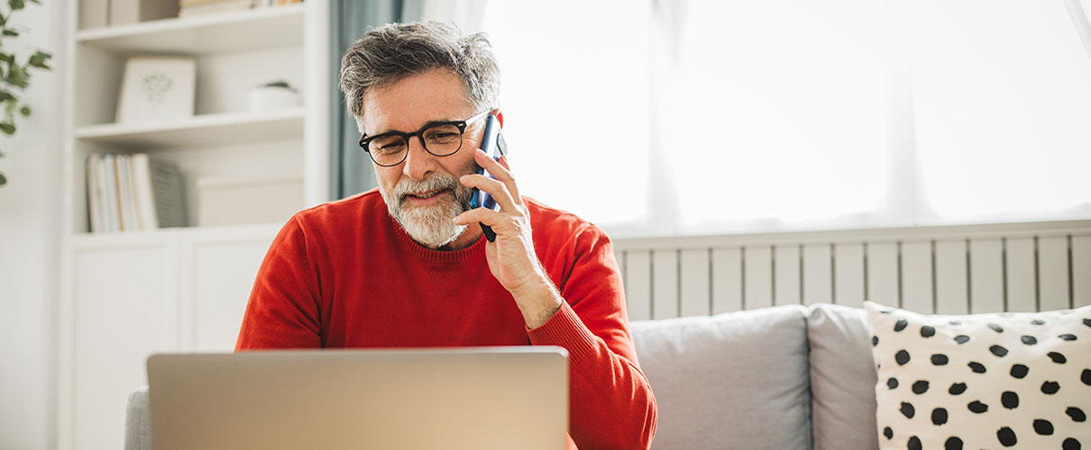 Smiling middle-aged man talking on smartphone