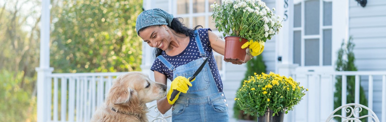 A woman gardening with a gracefully aging golden retriever
