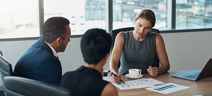 Female financial advisor reviewing documents with couple