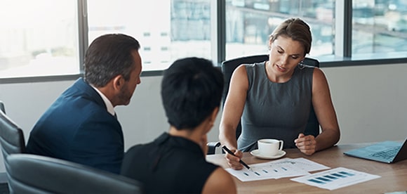 Female financial advisor reviewing documents with couple