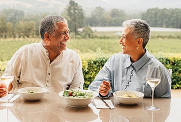 Smiling senior couple eating dinner outdoors