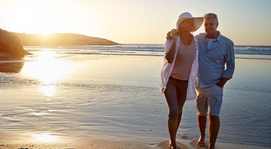Couple walking on the beach at sunset